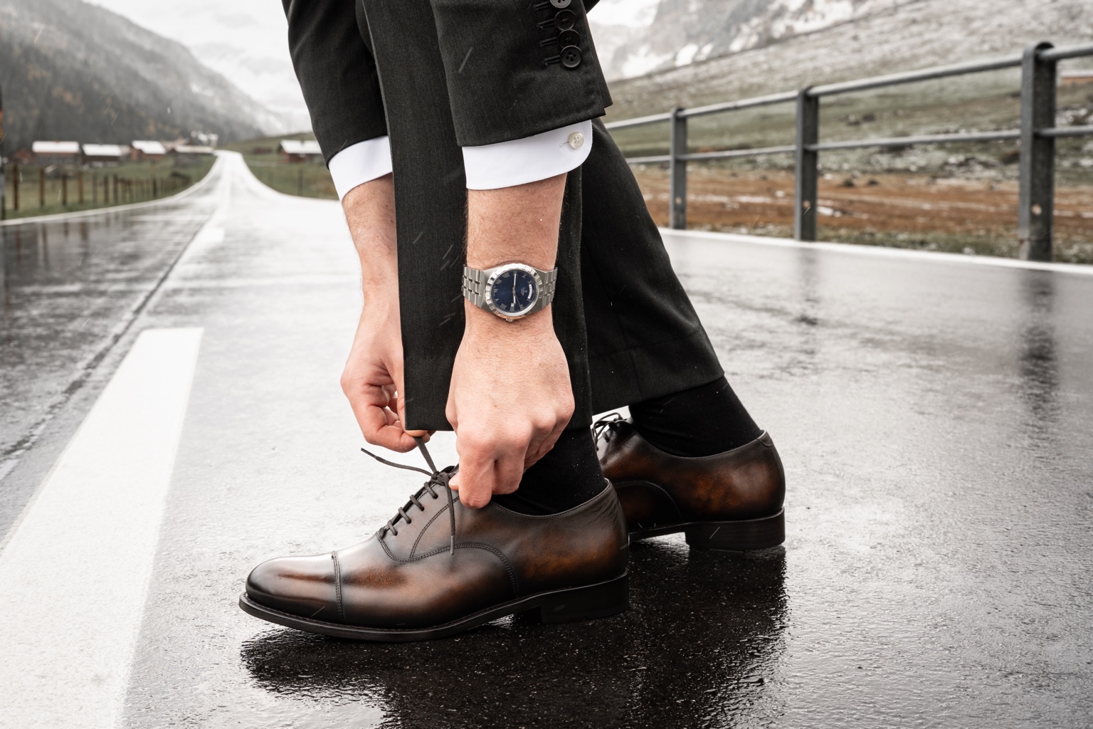 FEURING Oxford mit brauner Patina, getragen zum dunklen Anzug auf einer Bergstrasse auf dem Urnerboden in der Schweiz